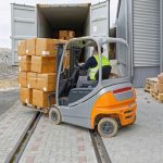 A forklift loading boxes into a truck.
