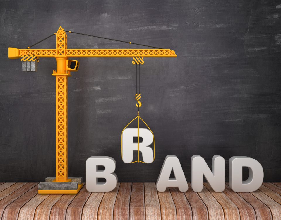 A crane lifting the "B" in "Brand"